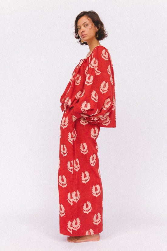 Ria Pants Ruby Red — studio lower body detail, model wearing ruby red hand block print cotton wide-leg pants with botanical leaf motif, elastic waist and relaxed flowing fit, artisan Jaipur India | Daughters of India