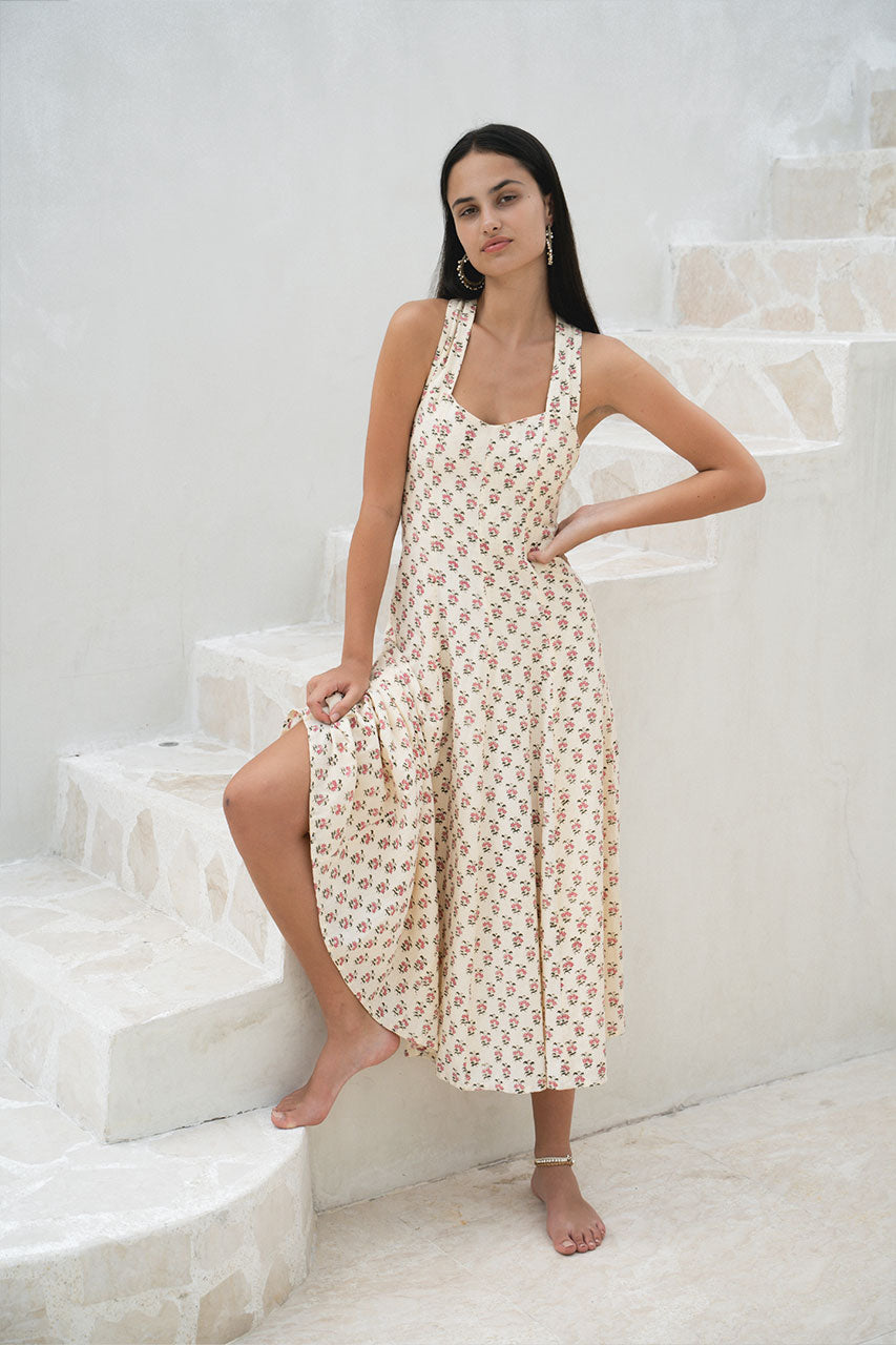 Lalika Dress Peony — full length front view in villa courtyard, peony hand block print cotton wrap dress, cream with pink floral motifs, white-walled tropical villa setting | Daughters of India